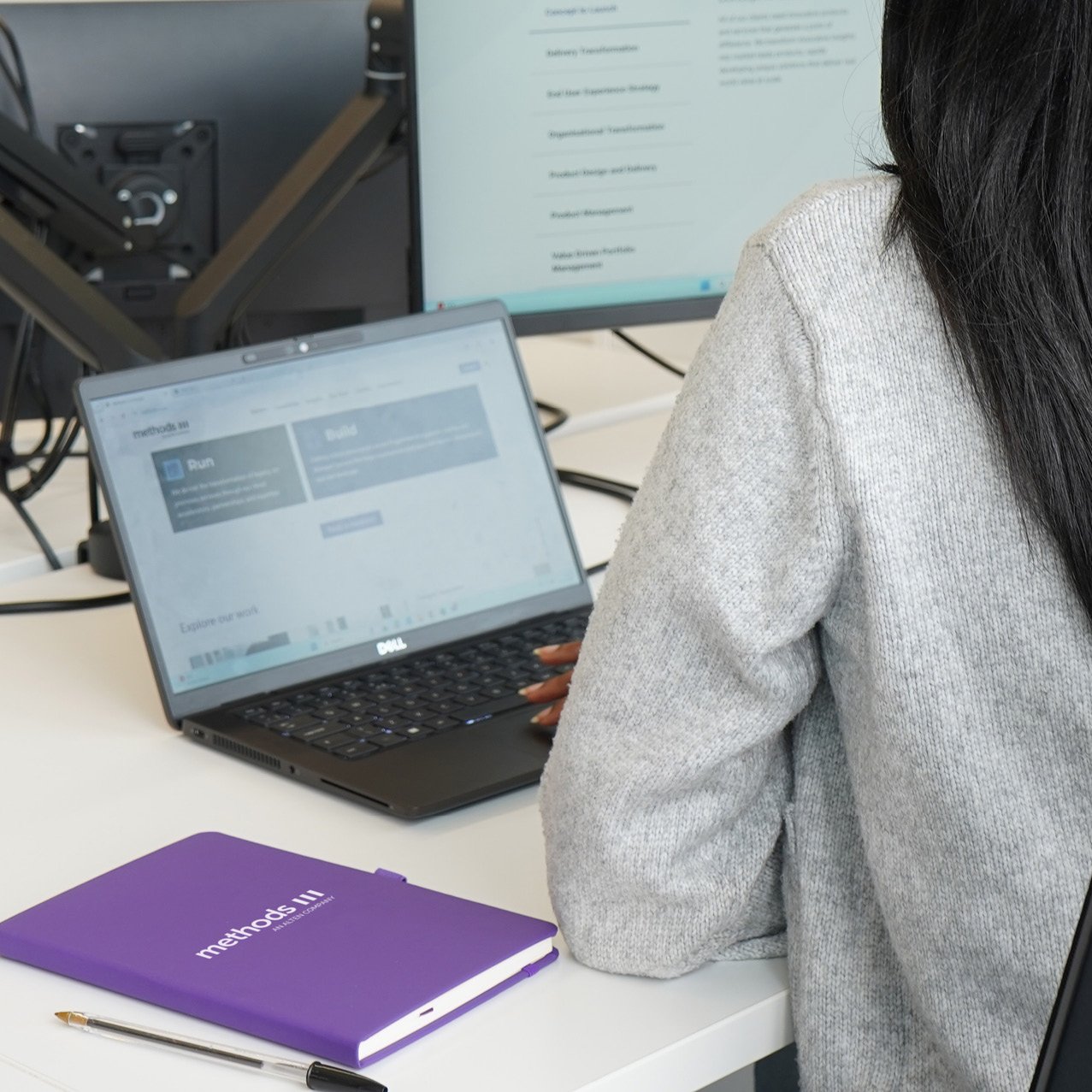 Decorative photo of a Methods employee working on a desk in the office