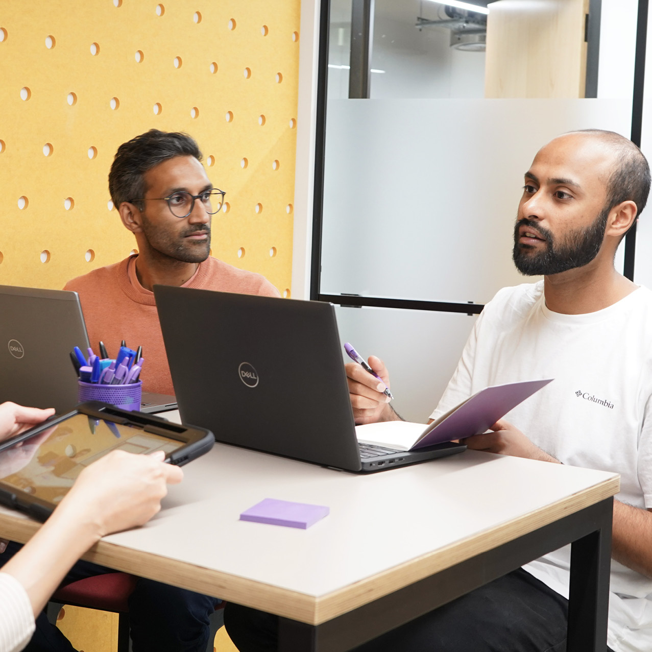 Decorative photo of Methods employees working together on a desk in the office