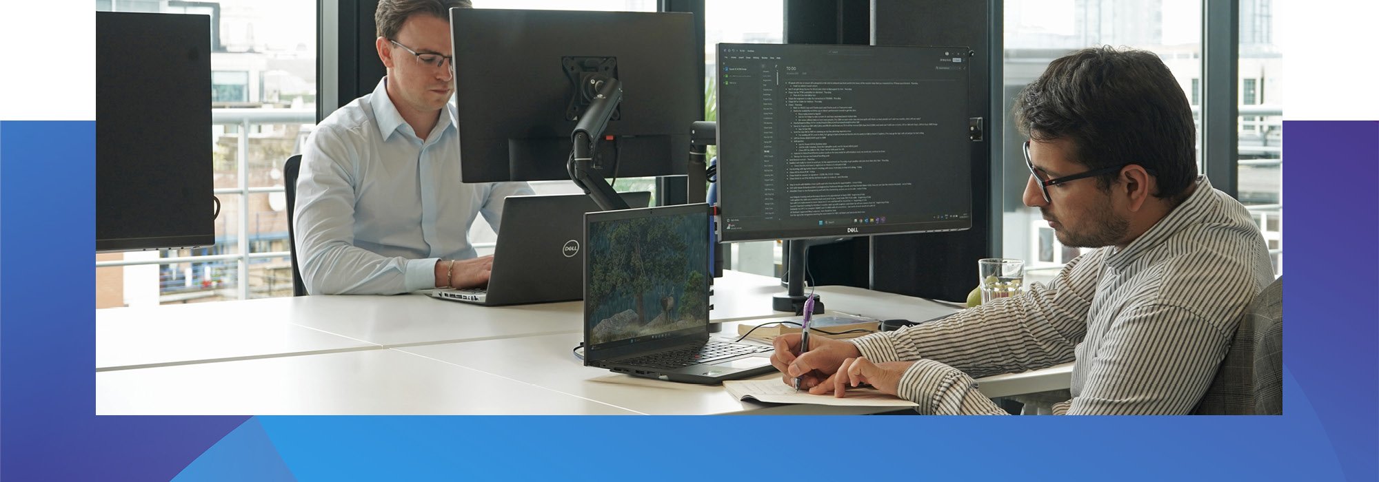 Decorative photo of Methods employees working on a desk in the Methods office