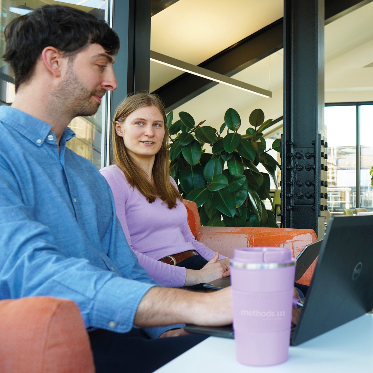 Decorative photo of Methods employees having a relaxed team discussion on the office sofa